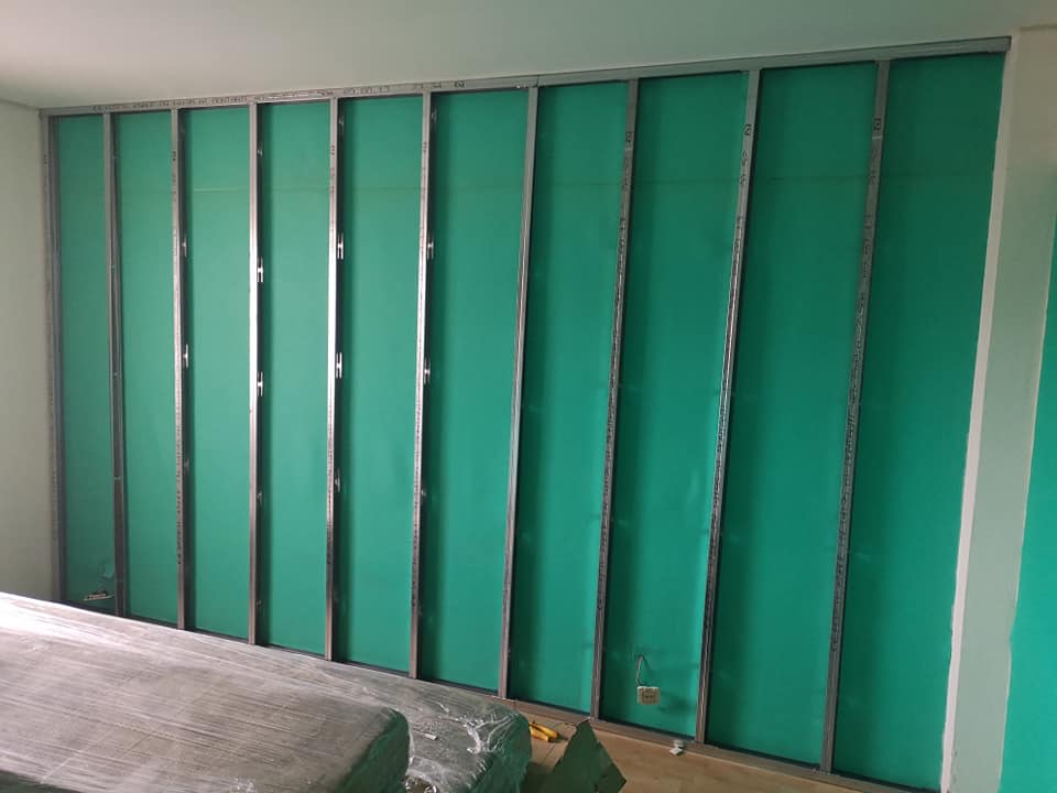 Montaje de tabiquería con aislamiento acústico y térmico integrado. Instalación de lana de roca de alta densidad entre p